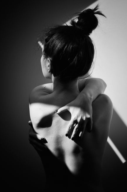 Artistic black and white portrait of a woman from behind, in solitude.